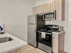 A modern kitchen with stainless steel appliances, a microwave, and a stove.