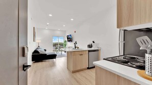 A modern kitchen with a central island, built-in dishwasher, and a stove. - Charming 1BR Home | Fishtown | Steps to Cafe & Gym (Philadelphia)