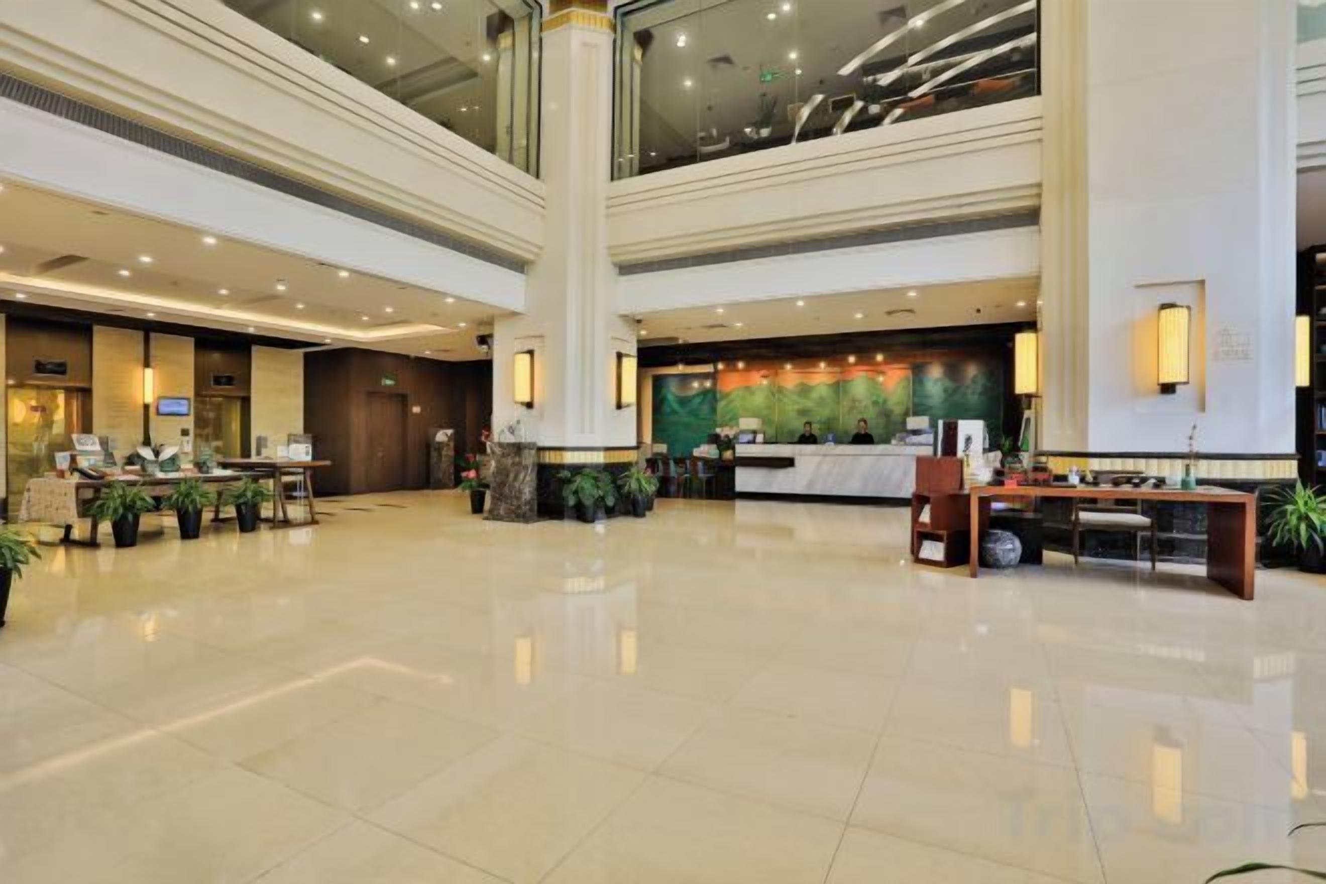 A spacious lobby with a reception desk, seating area, and a large pillar.