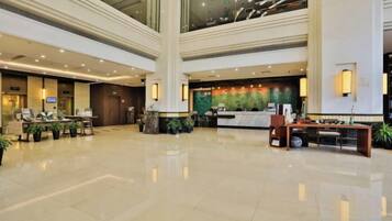 A spacious lobby with a reception desk, seating area, and a large pillar.