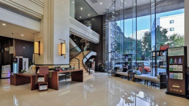 A spacious lobby with a staircase, seating area, and display shelves. - Hangzhou Wenhua GINLAN JIA Grand Hotel (Hangzhou)
