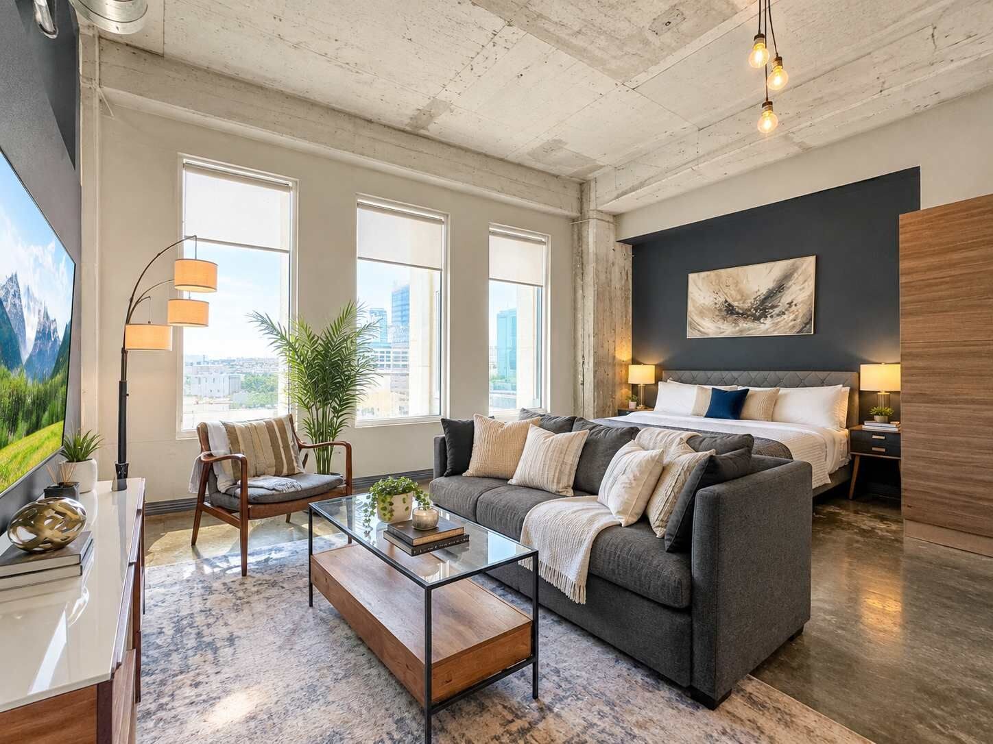 A modern living room with a sofa, coffee table, and a large window with a city view.