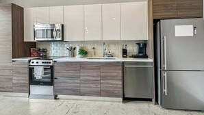 A modern kitchen with a stainless steel refrigerator, oven, and microwave.