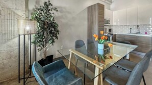 A modern kitchen with white cabinets, a microwave, and a sink.