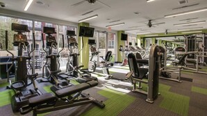 A gym with various exercise equipment, large windows, and a green carpeted floor. - 1BR Uptown Oasis Sleeps 4 | Near Klyde Warren Park (Dallas)