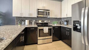 Una cocina moderna con microondas, estufa, horno y refrigerador.