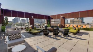 Terraza en la azotea con asientos al aire libre, una chimenea y vistas de la ciudad.