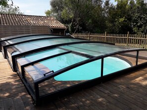 A swimming pool with a glass enclosure, surrounded by a wooden deck and a wooden fence. - RENOVATED WINEMAKER'S HOUSE FOR 8 BETWEEN THE SEA AND THE MOUNTAINS; POOL AND GARDEN (Puimisson)