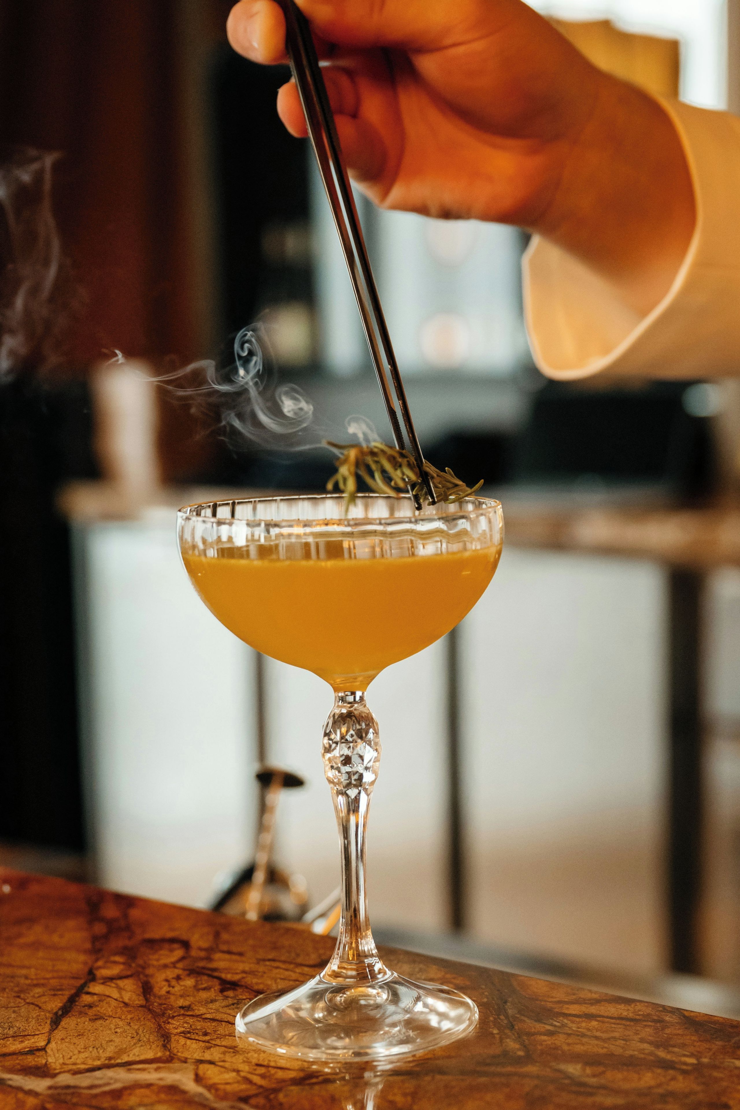 A cocktail in a glass with a stem, placed on a wooden surface.