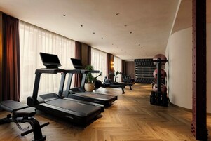 A gym with treadmills, a bench, and a rack of weights.