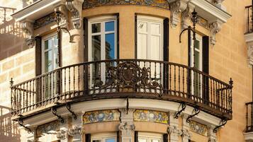 A corner building with ornate balconies, decorative tiles, and classical architectural elements.