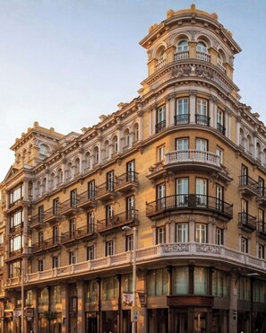 A multi-story building with ornate architectural details, including balconies and large windows. - Nômade Temple Madrid (Madrid)
