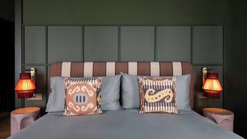 A bed with two pillows, two nightstands, and two wall-mounted lamps.