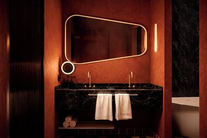 A modern bathroom with a marble vanity, two sinks, a large mirror, and a towel rack. - Nômade Temple Madrid (Madrid)