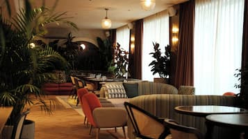 Un salón amplio con diversas opciones de asientos, incluyendo sofás y sillones, además de un comedor con mesa y sillas.