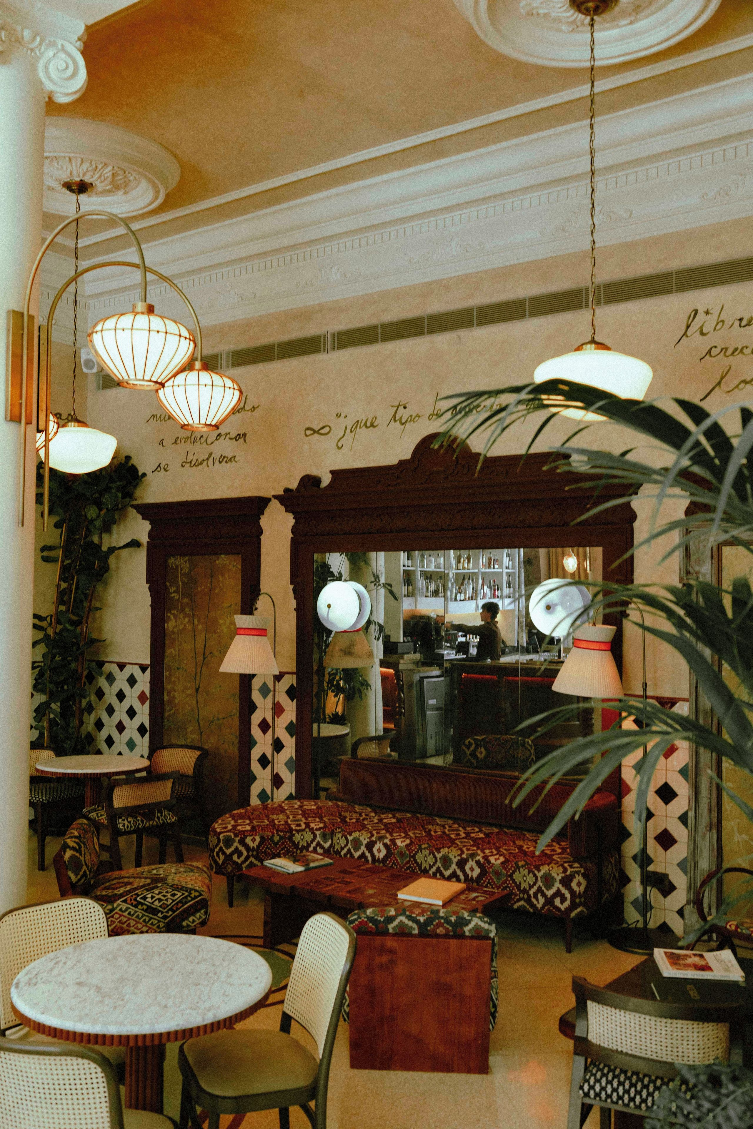Un interior acogedor con una zona de bar, asientos y una iluminación decorativa.
