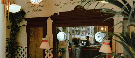 Un interior acogedor con una zona de bar, asientos y una iluminación decorativa.