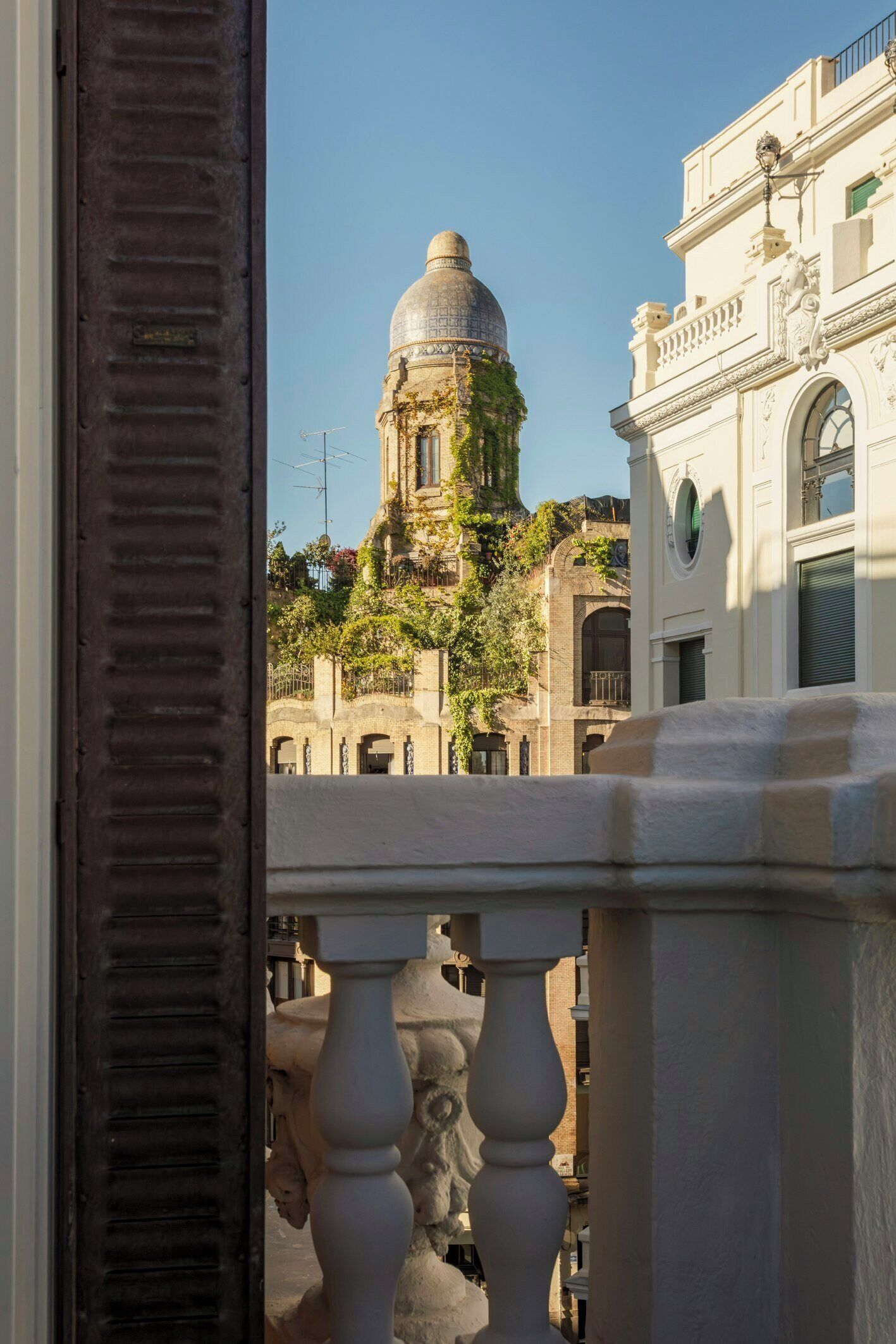 A view of a building with a dome and a balcony railing.