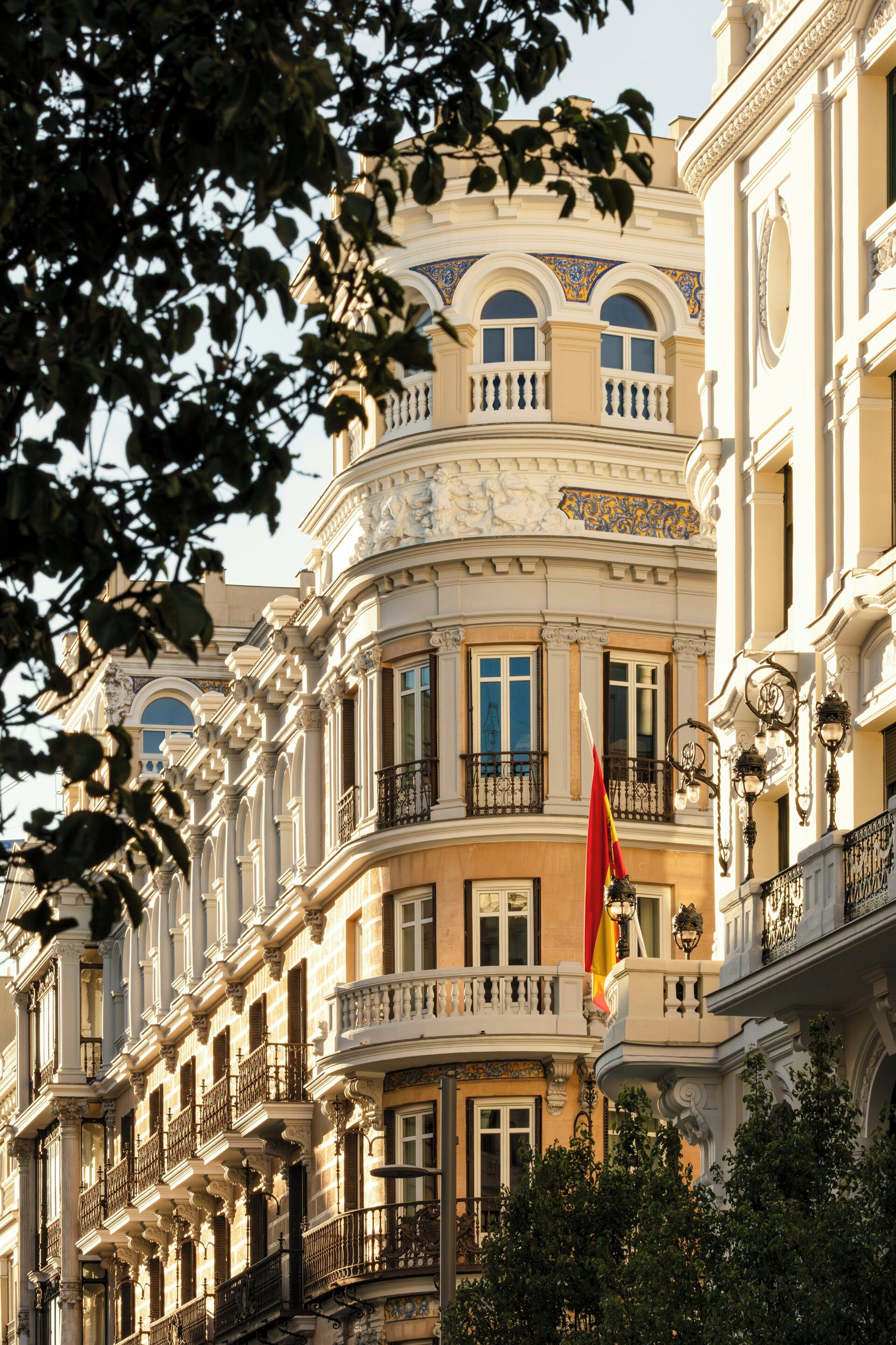 A multi-story building with ornate balconies and a flag.