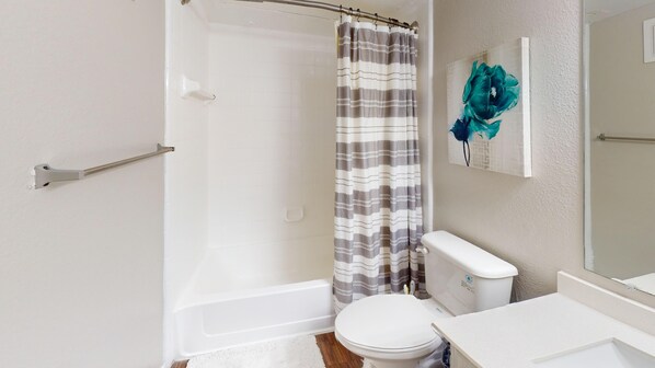 A bathroom with a shower, toilet, and sink.