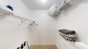 A small, white-walled room with a single white radiator, a white ceiling fan, and a white shelf with folded towels. - I241 - Apt|Patio|10mi to Convention Ctr|Sleeps 4 (Irving)