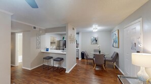 A modern apartment with a kitchen, dining area, and a living room.