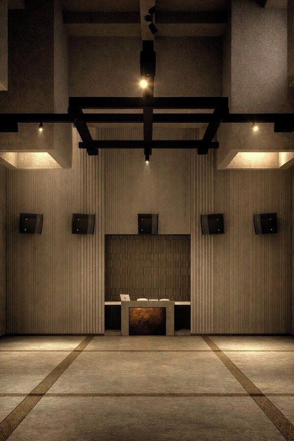 A spacious lobby with a reception desk, vertical wooden paneling, and ceiling-mounted lighting.