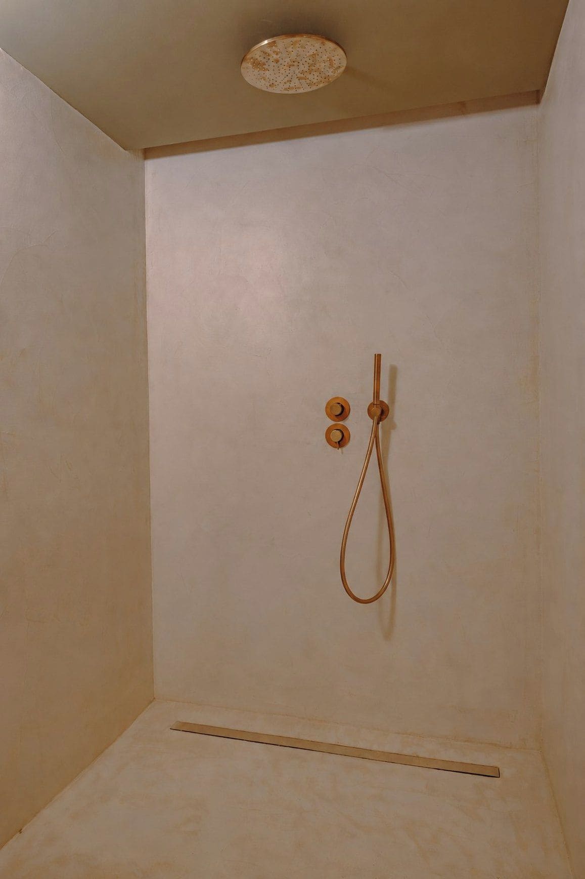 A small, enclosed shower area with a single showerhead and a control knob.