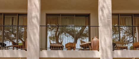 A multi-story building with balconies, large windows, and outdoor seating areas.