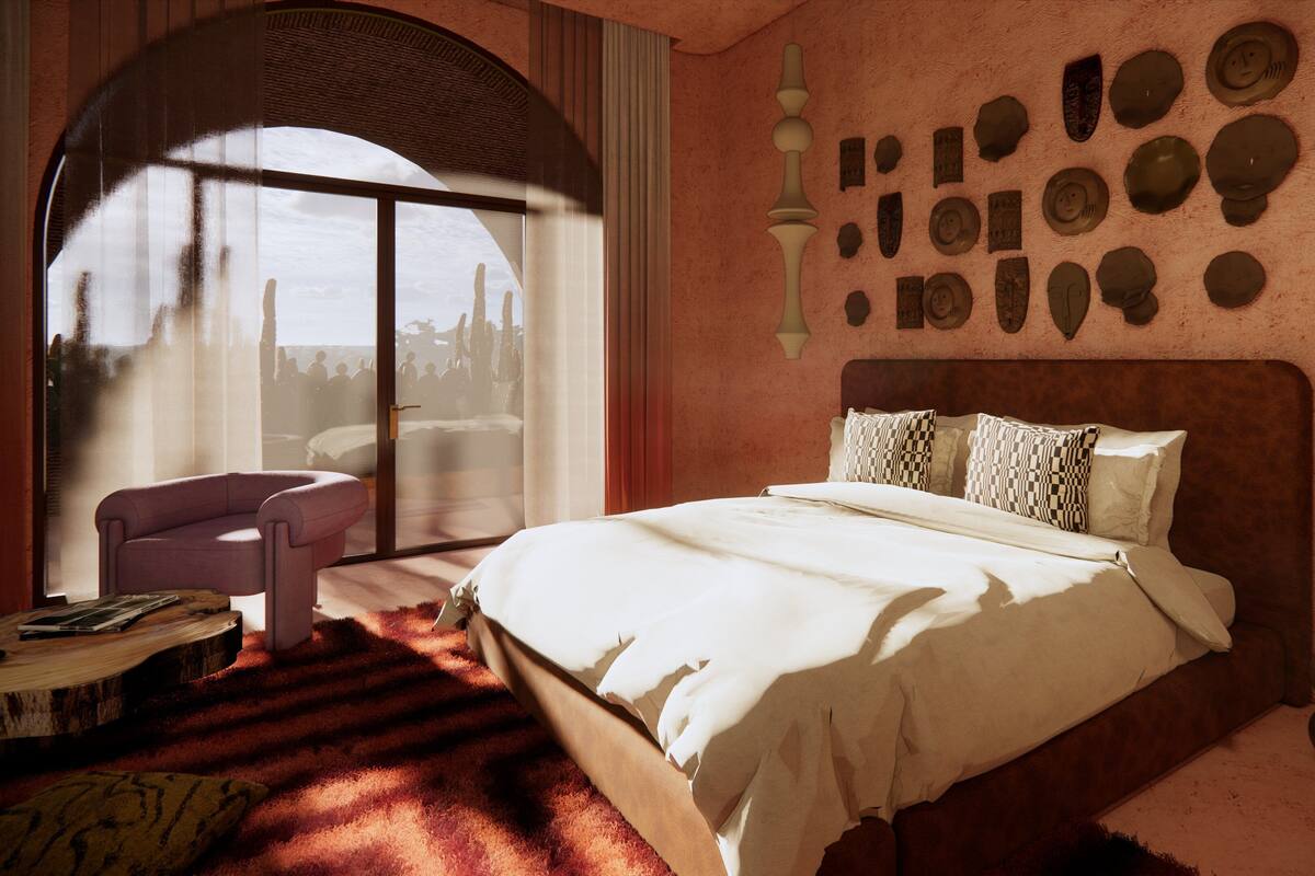 A bedroom with a large bed, a chair, a round coffee table, and a view through a window.