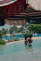 Una piscina al aire libre de temporada, sombrillas, tumbonas