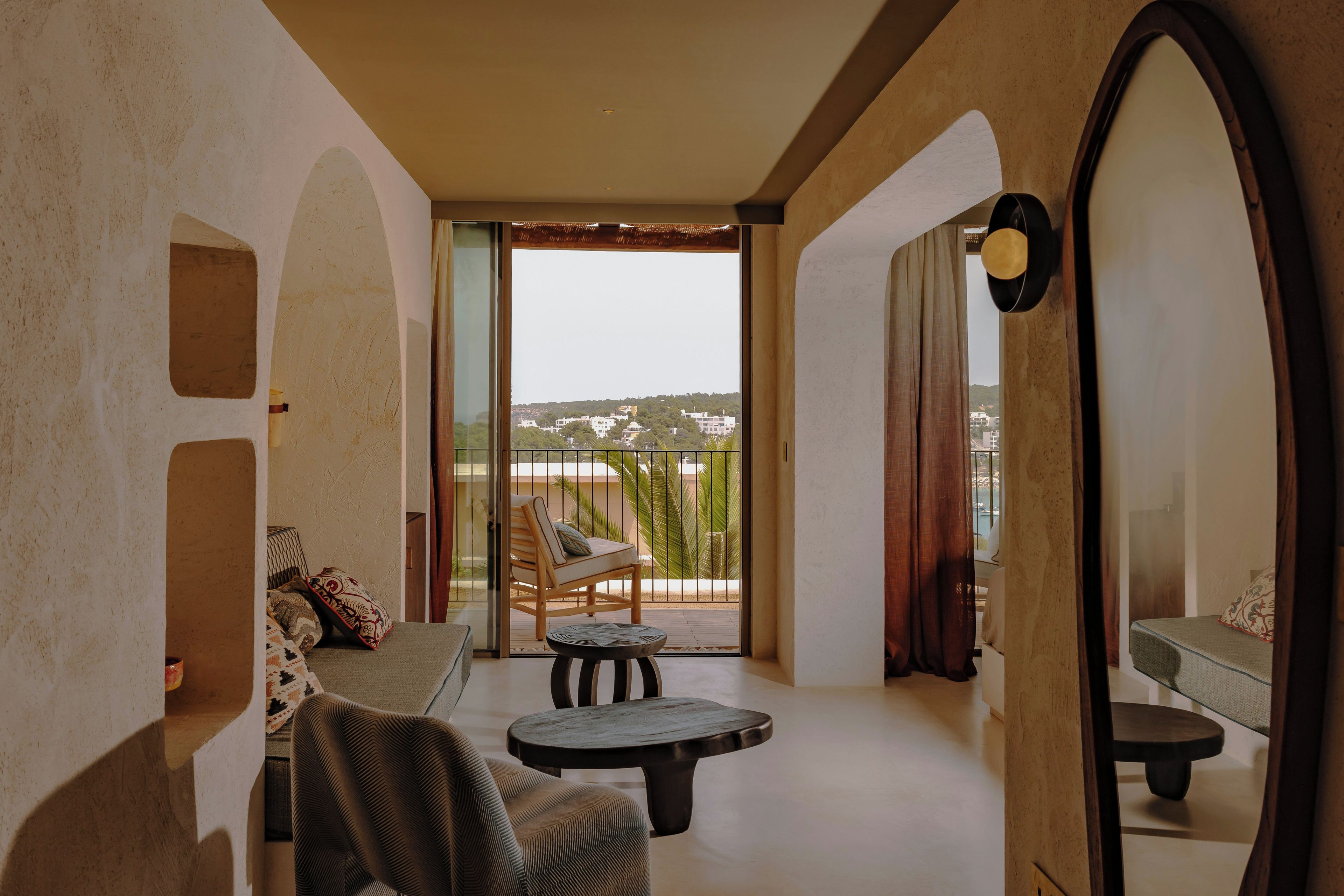 A balcony with a sofa, a chair, and a small table.