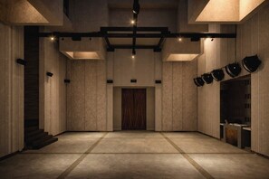 A spacious, modern interior with a central staircase, recessed lighting, and a patterned wall design.