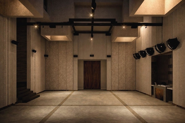 Un interior espacioso y moderno con una escalera central, iluminación empotrada y un diseño de pared con motivos.
