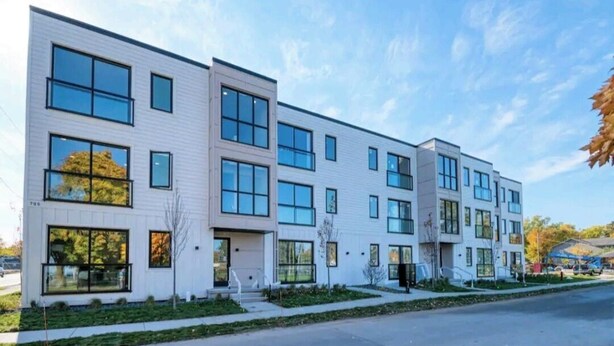 Un edificio moderno de varios pisos con amplias ventanas y techo plano.