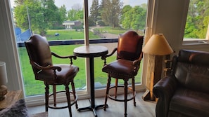 Enjoy a peaceful view from the large window, with a comfortable seating area featuring a sofa and two chairs.