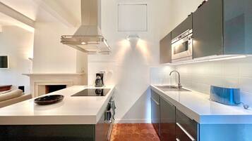 A modern kitchen with a central island, stainless steel appliances, and a sleek design.