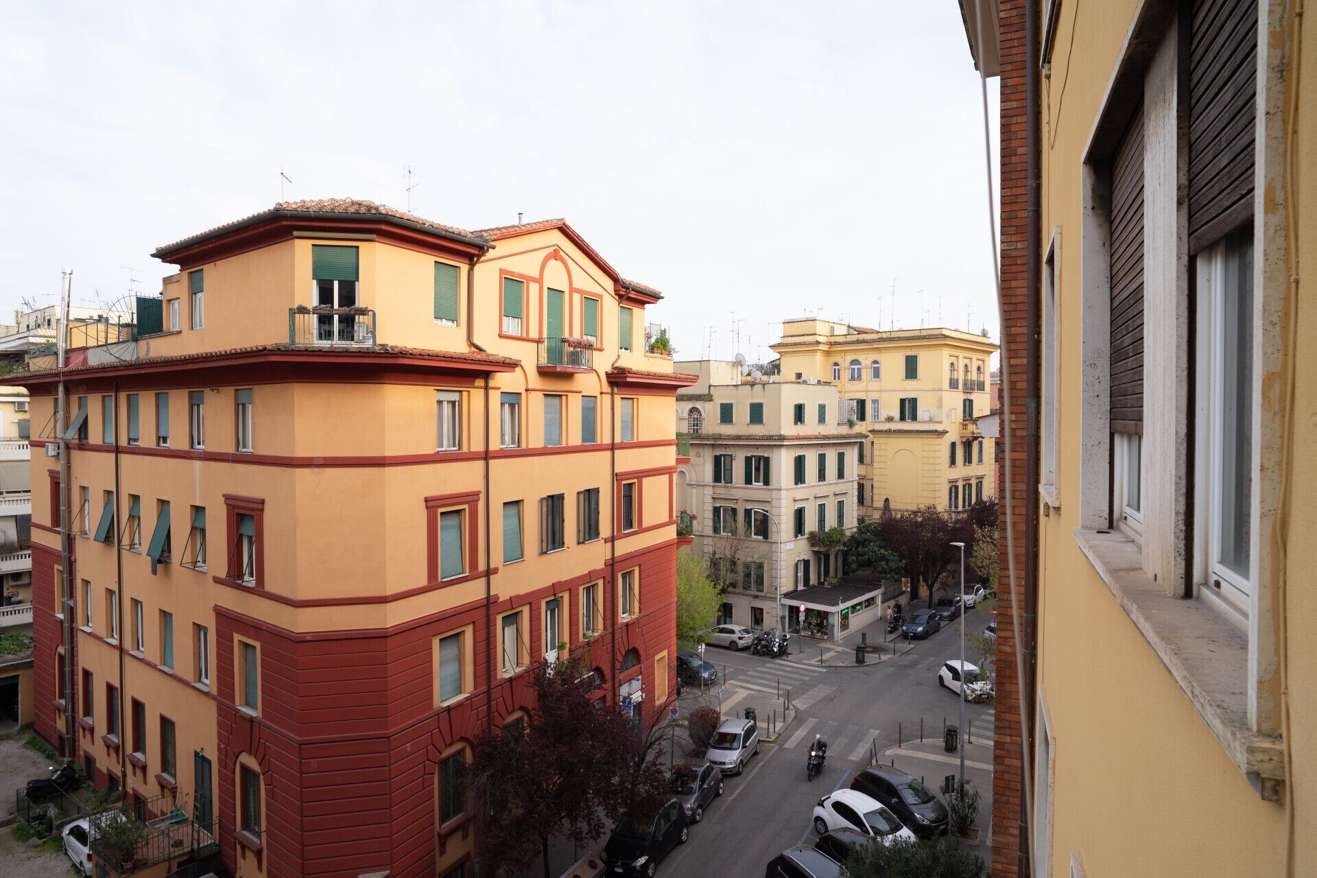 Un edificio a più piani con facciata rossa e gialla, numerose finestre e balconi.