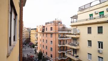 Un edificio residenziale a più piani con balconi, condizionatori d'aria e vista sulla strada.