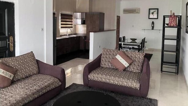 Un soggiorno con due divani decorati, un tavolino da caffè e una zona pranzo con tavolo e sedie.