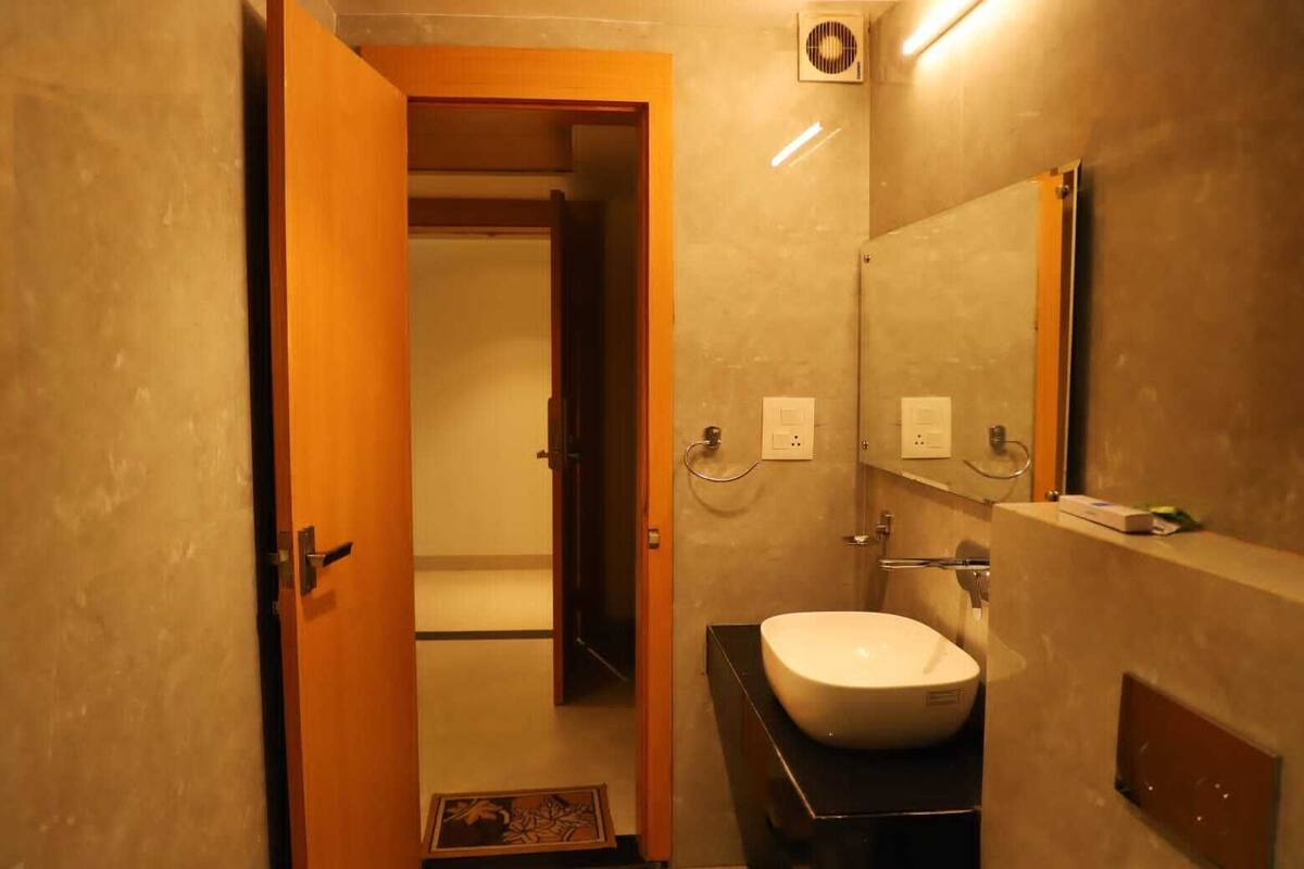 Casa de banho com lavatório, espelho e porta-toalhas.