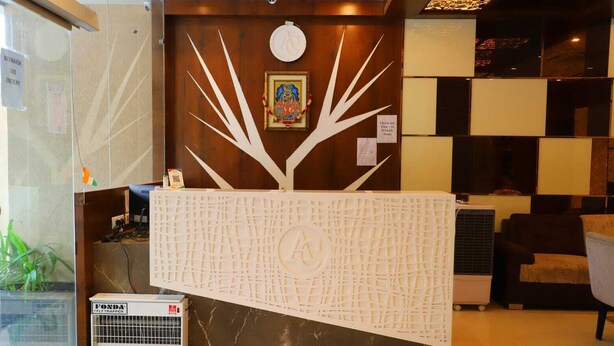 A reception desk with a unique tree design, a clock, and a check-in counter. - Ananda Castle (Vrindavan)