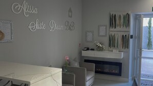 A modern interior with a dining area, a fireplace, and decorative wall art. - Alissa Suite (Rome)