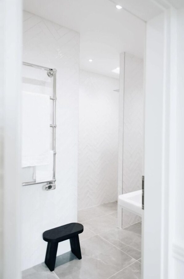 Une salle de bain moderne avec une douche, un banc et un miroir.