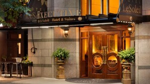 L’extérieur de l’hôtel Le Soleil se distingue par son imposante entrée, avec ses doubles portes, ses plantes en pot et une enseigne placée au-dessus des portes.