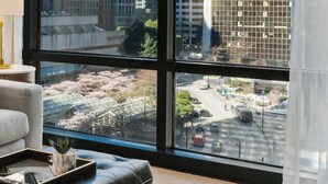 Une chambre moderne dotée de grandes fenêtres donnant sur un paysage urbain et un pont.