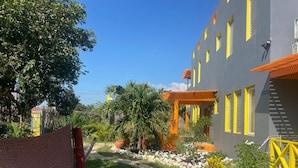 A building with a modern design, featuring a pathway leading to the entrance. - The Bakers Villa- Old Wharf Limited (Treasure Beach)