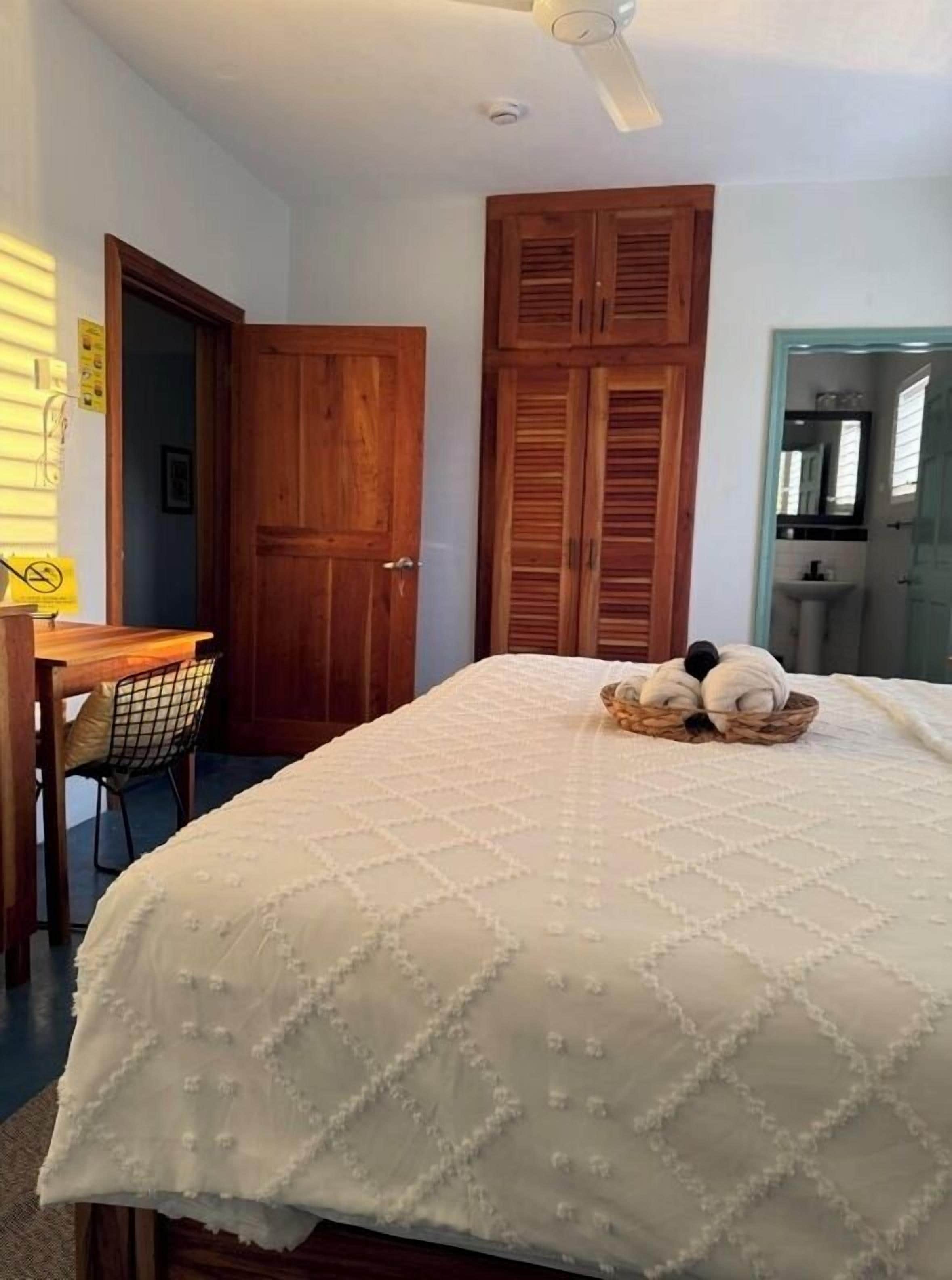 A bedroom with a bed, a desk, a chair, and a wardrobe.