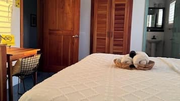 A bedroom with a bed, a desk, a chair, and a wardrobe.