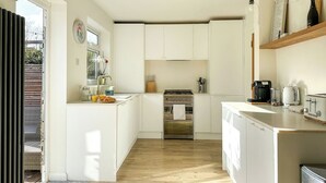 A modern kitchen with white cabinetry, a built-in oven, a coffee maker, and a toaster. - Modern 3 Bed Home - Pets Welcome + FREE Parking (Canterbury)
